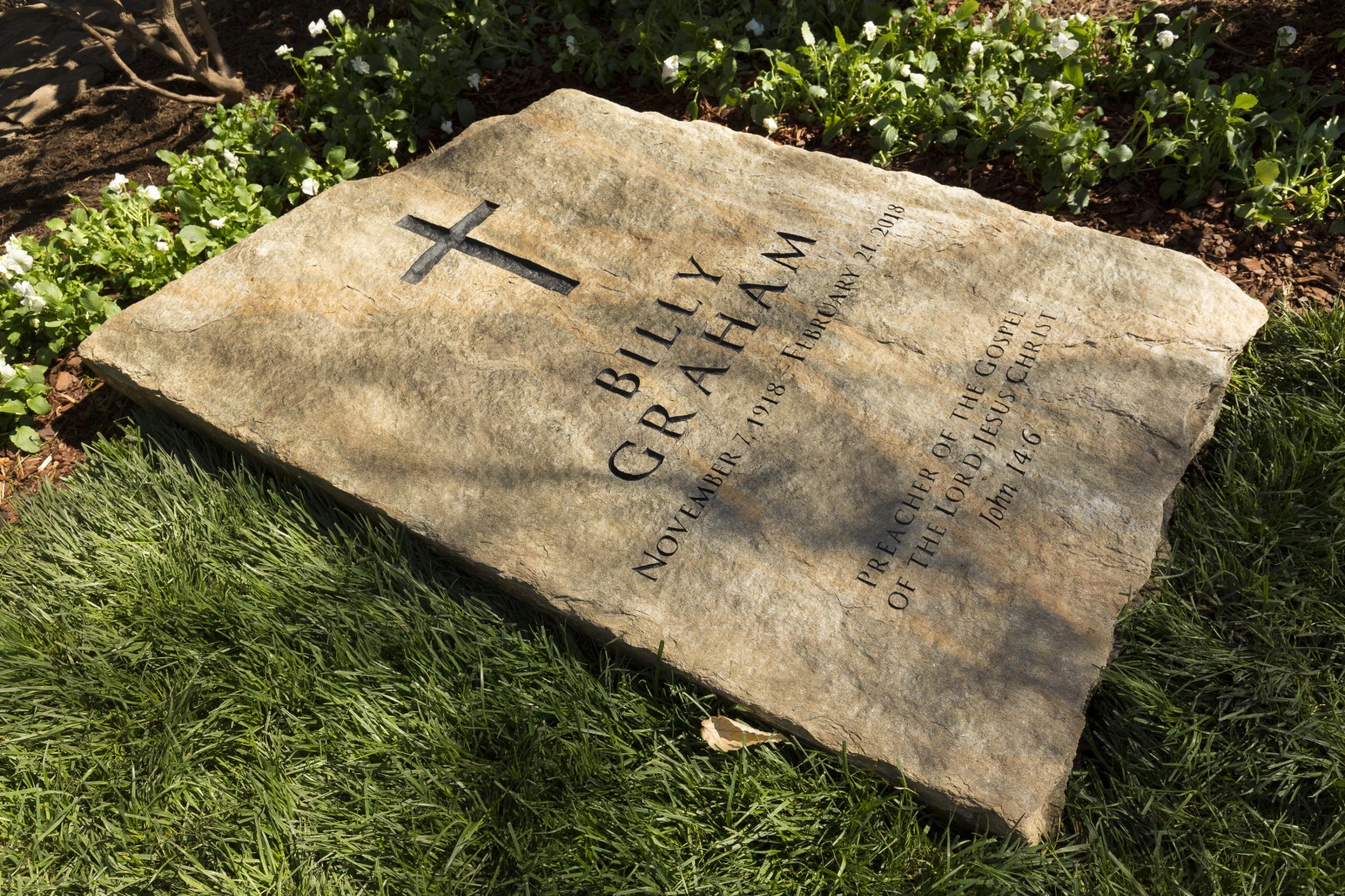 A slab of North Carolina stone marks the grave of Billy Graham, buried next to his wife, Ruth, at the Prayer Garden located next to the Billy Graham Library in Charlotte. The marker inscription bears the text, "Preacher of the Gospel of the Lord Jesus Christ" with the Scripture reference, John 14:6. (Billy Graham’s Grave Marker)