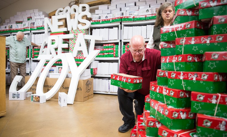 Pastor Mark Brumbelow and his wife Cherry pray over Operation Christmas Child shoeboxes during a service at Grace Baptist Church in Wild Peach, Texas. Today: US Hurricane Victims “Pay It Forward” to Help Children of Storm-Ravaged Barbuda