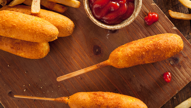 · Corn dogs: Corn dogs are essentially hot dogs on a stick that have been covered in cornmeal and fried. Like funnel cakes, corn dogs have become so synonymous with fairs and carnivals that few people have ever enjoyed them anywhere outside of their local fairgrounds.